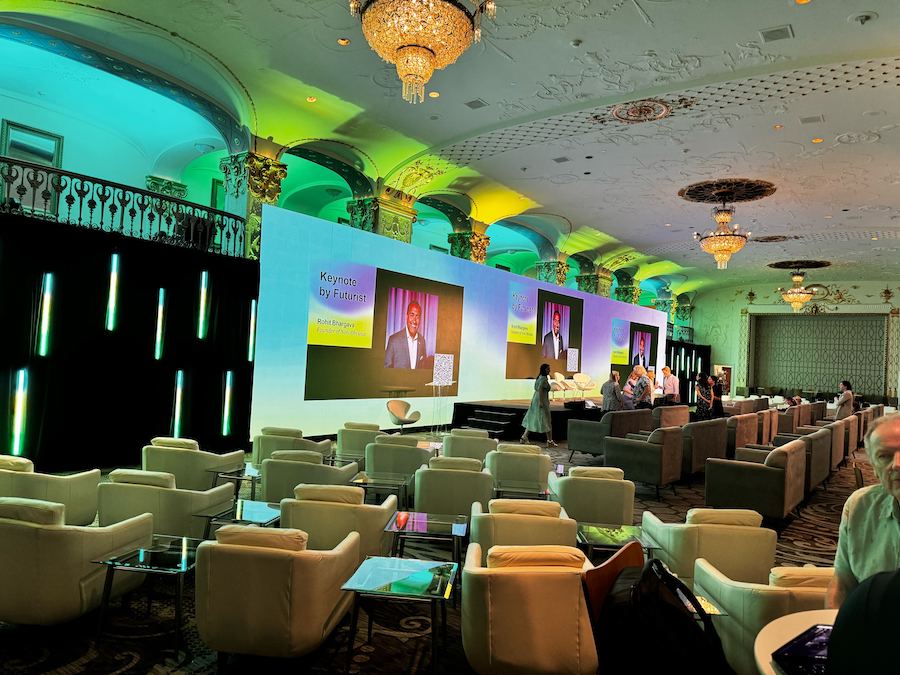 Large LED wall display in a conference hall with empty seating in the foreground.
