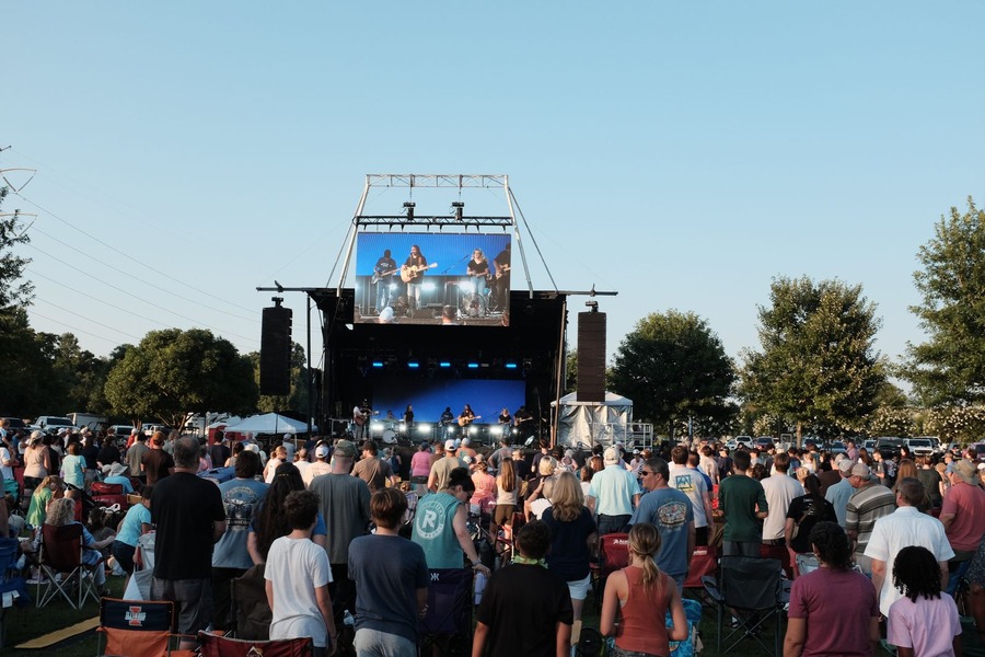 outdoor concert stage with people dancing to the music the performers are playing