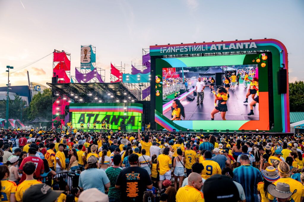 View of stage with talent performing for crowd of people at the FIFA Fan Festival Atlanta